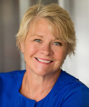Headshot of Mary in a blue blouse smiling