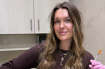 Jenna holding a needle in her medical office